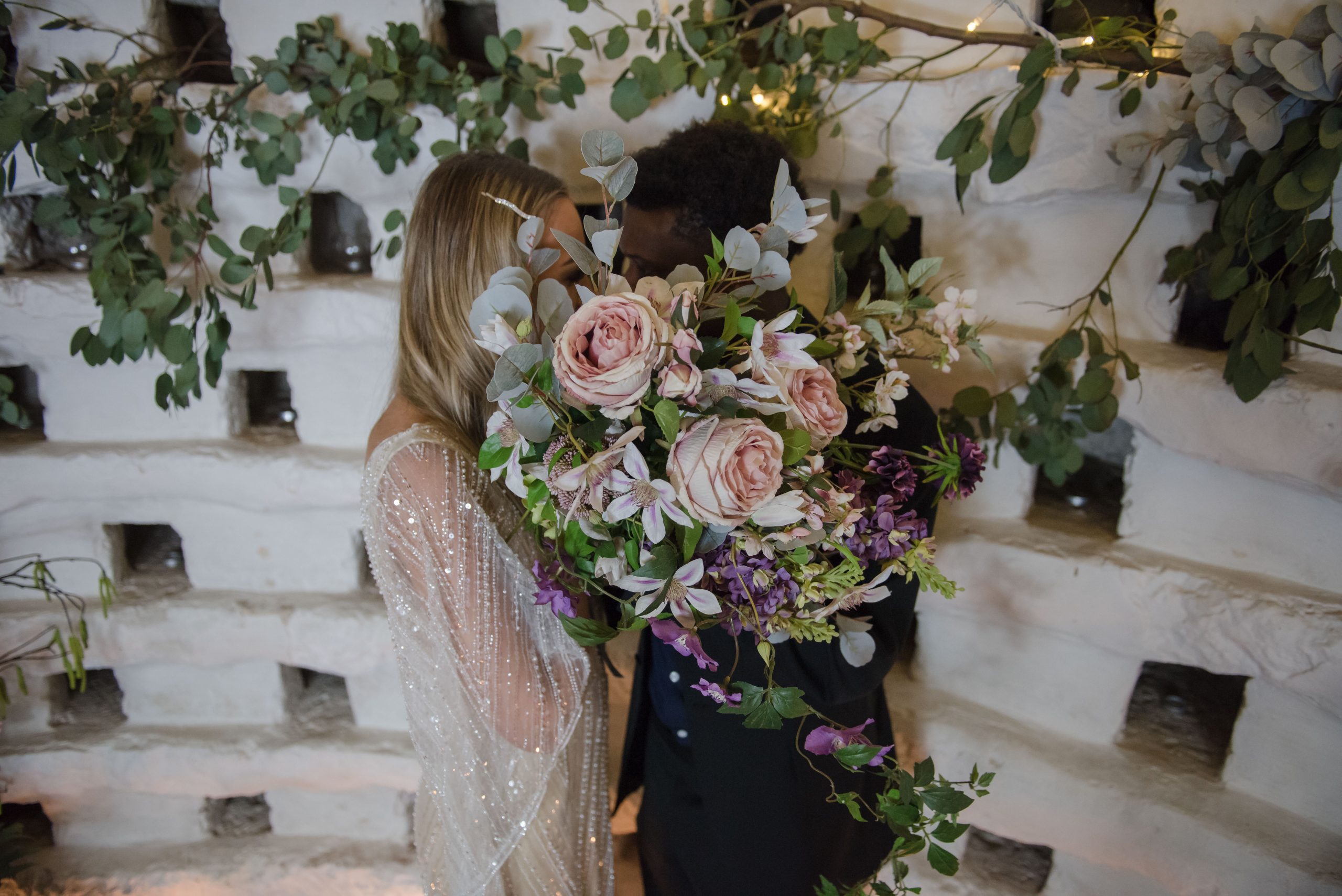 couple hiding behind a bouquet
