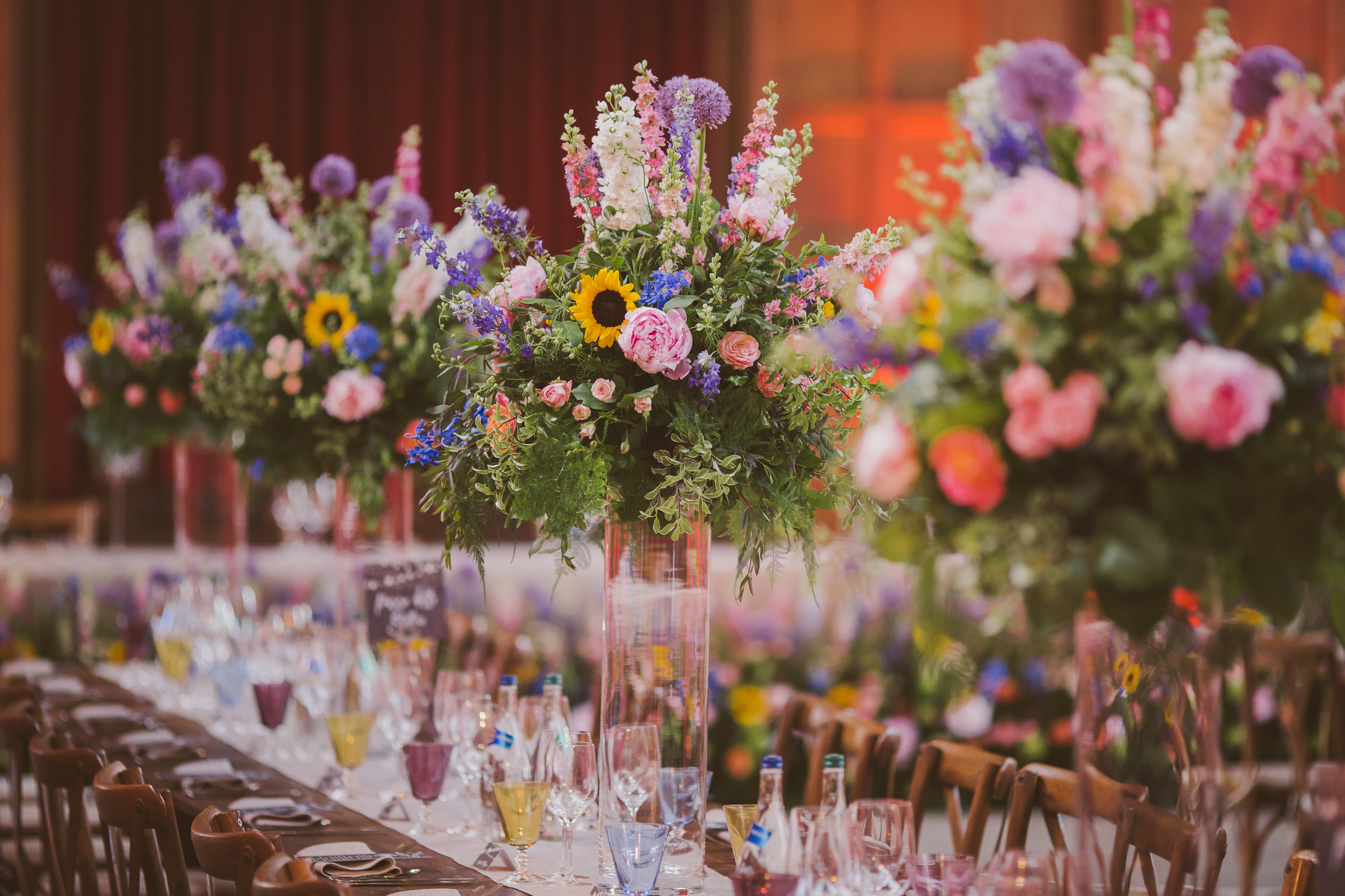 Summer flowers in tall vases for a wedding breakfast