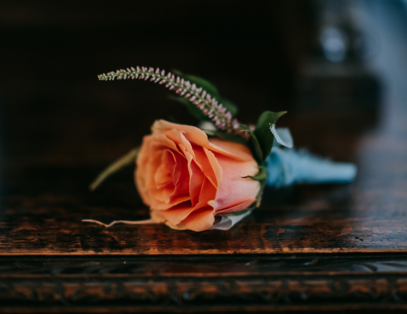 An orange rose buttonhole at the Castle Westenhanger Kent by Fleur Challis Photography with E-Lope